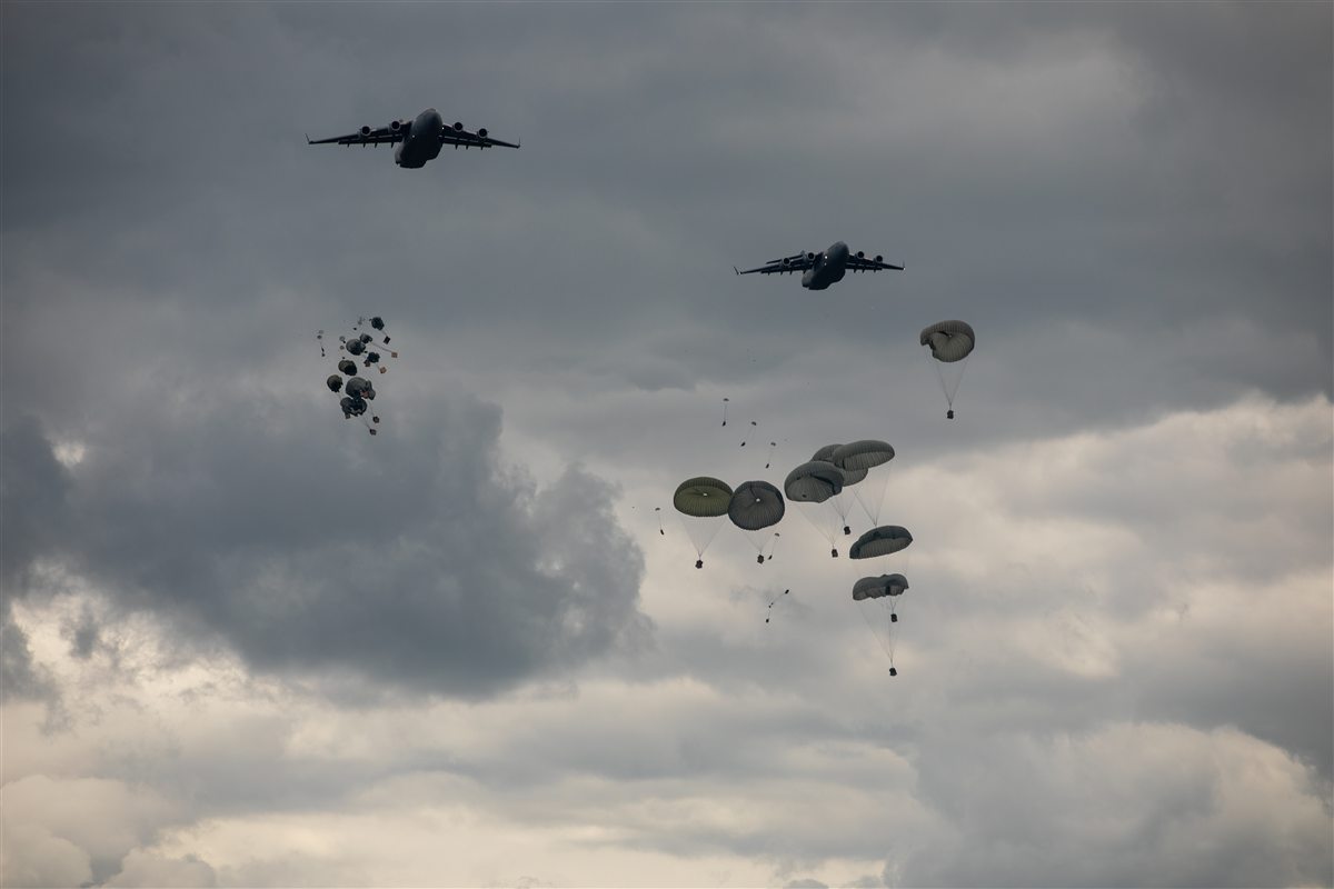 U.S. Army Airborne paratroopers descending under canopy in a mass tactical jump